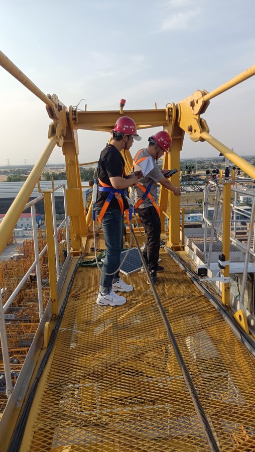 Checking tower crane safety monitoring readings against the parameter sheet on site